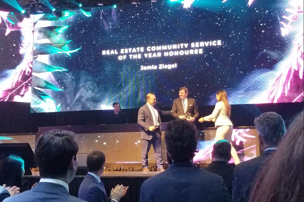 Jamie Ziegel receiving the NAIOP REX Real Estate Community Service award on stage